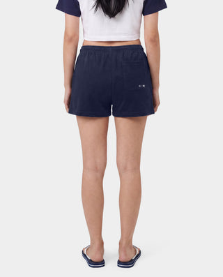 The LA Serif Disco Short in Dark Navy/White is a pair of super-short, cotton fleece shorts featuring Sports&Rich and LA logos on the front, made in the USA and displayed laid flat on a white background.