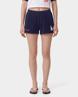 The LA Serif Disco Short in Dark Navy/White is a pair of super-short, cotton fleece shorts featuring Sports&Rich and LA logos on the front, made in the USA and displayed laid flat on a white background.
