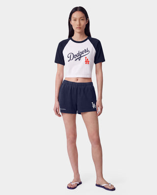 The LA Serif Disco Short in Dark Navy/White is a pair of super-short, cotton fleece shorts featuring Sports&Rich and LA logos on the front, made in the USA and displayed laid flat on a white background.