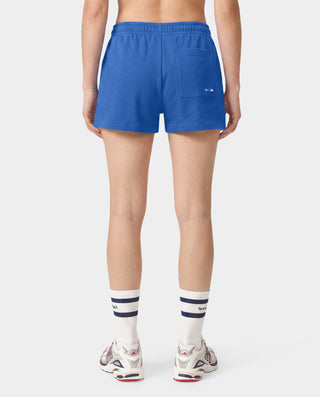 Introducing the LA Serif Disco Short in Team Blue/White—crafted from athletic cotton fleece and featuring an elastic waistband. These shorts showcase "Sports & Rich" alongside a striking white LA logo on the front, displayed laid flat against a white background. Proudly made in the USA.