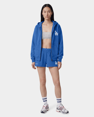 Introducing the LA Serif Disco Short in Team Blue/White—crafted from athletic cotton fleece and featuring an elastic waistband. These shorts showcase "Sports & Rich" alongside a striking white LA logo on the front, displayed laid flat against a white background. Proudly made in the USA.