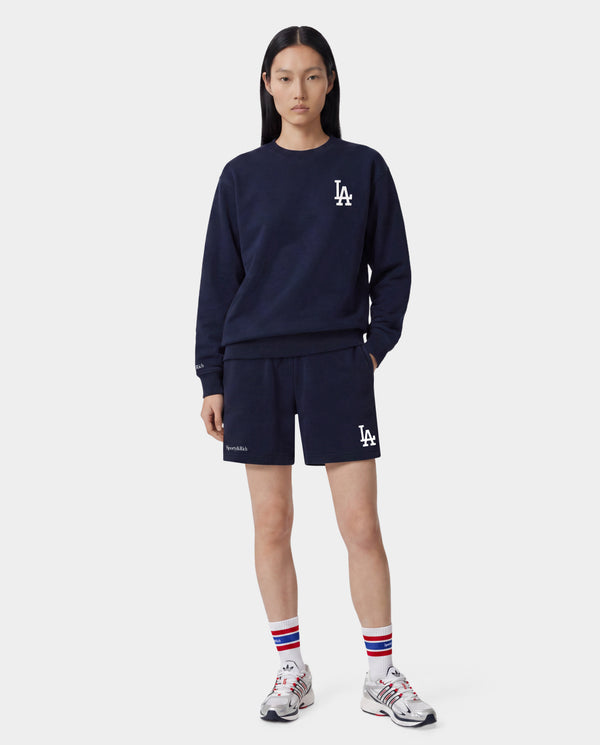 Dodgers Serif Gym Short in Dark Navy/White, featuring LA and Sporty & Rich logos on the front, an elastic waistband, crafted from 100% cotton in Portugal. Presented against a white background.