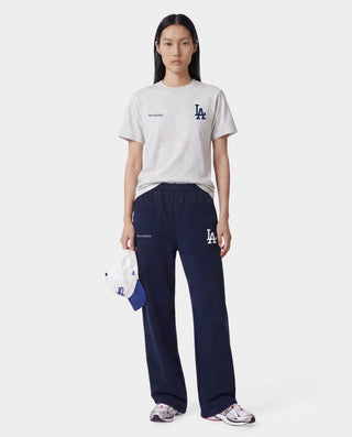 The LA Serif Wide Sweatpant in Dark Navy/White features a wide-leg, oversized fit crafted from 100% cotton and showcases a white LA logo along with Sporty & Rich text on the front, displayed lying flat on a white background.