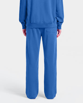 The LA Serif Wide Sweatpant in Team Blue/White features wide legs and showcases Sports Rich and LA logos on the front, crafted from soft cotton and displayed against a plain white background.