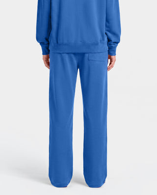 The LA Serif Wide Sweatpant in Team Blue/White features wide legs and showcases Sports Rich and LA logos on the front, crafted from soft cotton and displayed against a plain white background.