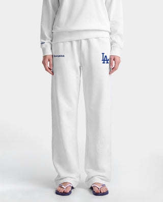 LA Serif Wide Sweatpant - White/Team Blue, crafted in Portugal from 100% cotton, features a wide-leg silhouette with blue LA and Sports Rich logos and is displayed on a plain light gray background.
