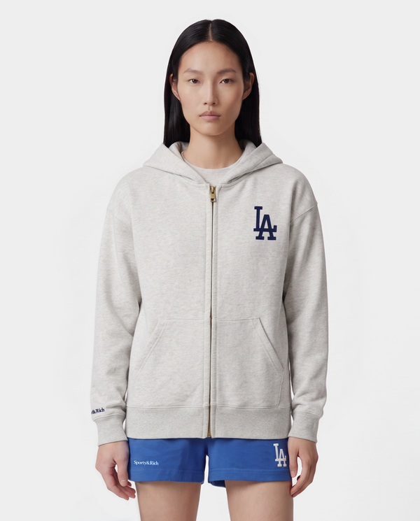LA Serif Zip Hoodie in Heather Gray/White, featuring a zipped front, LA logo on the chest, front pockets, and crafted from 100% cotton in an oversized fit, shown laid flat on a white background.