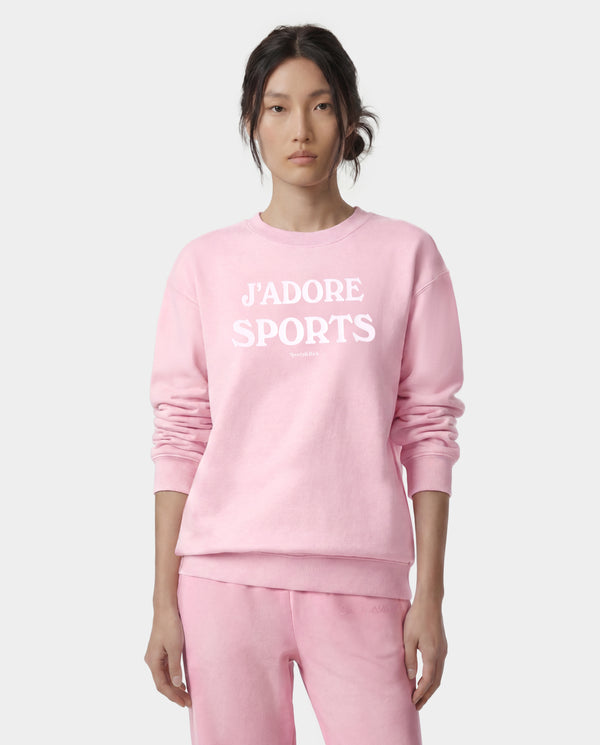Jadore Flocked Crewneck - Laffy/White, an oversized light pink sweatshirt with "JADORE SPORTS" printed in white on the front, is laid flat on a gray background. Proudly made in the USA.
