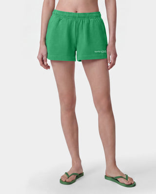 Green athletic shorts with an elastic waistband and a small white 'Sporty & Co.' logo on the lower left leg, shown flat against a light gray background.
