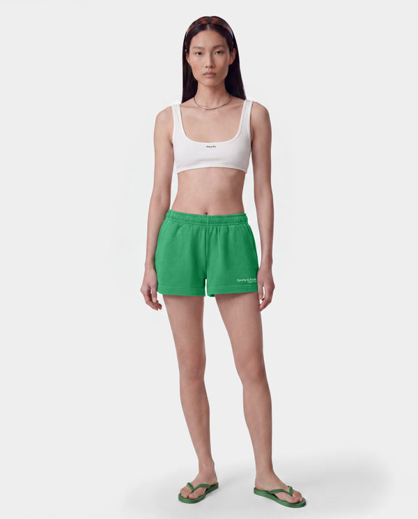 Green athletic shorts with an elastic waistband and a small white 'Sporty & Co.' logo on the lower left leg, shown flat against a light gray background.