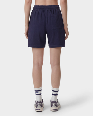 The HWCNY Gym Short in Dark Navy/White, made in the USA and crafted from 100% cotton for superior comfort and breathability, features a white Sporty & Rich print on the left leg and is displayed laid flat on a white background.
