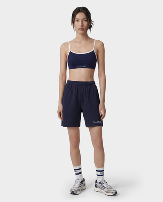 The HWCNY Gym Short in Dark Navy/White, made in the USA and crafted from 100% cotton for superior comfort and breathability, features a white Sporty & Rich print on the left leg and is displayed laid flat on a white background.