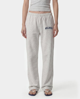 Wellness Ivy Wide Sweatpant in Heather Gray/Light Navy, featuring "WELLNESS" text on the left pocket and crafted from 100% cotton with an elastic waistband, displayed on a plain white background.