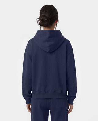 Wellness Ivy Zip Hoodie in Dark Navy/White—crafted in Portugal from 100% cotton, featuring a white WELLNESS print on the left chest and a zip-up hooded design.