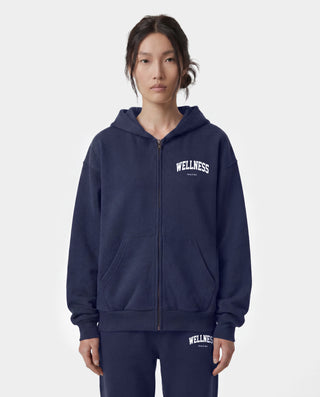 Wellness Ivy Zip Hoodie in Dark Navy/White—crafted in Portugal from 100% cotton, featuring a white WELLNESS print on the left chest and a zip-up hooded design.