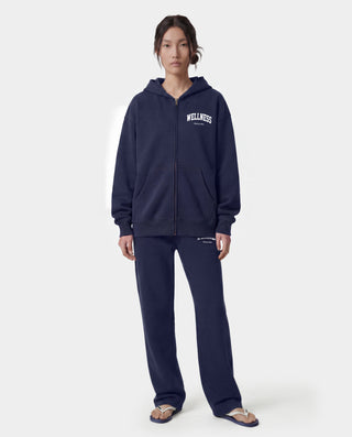 Wellness Ivy Zip Hoodie in Dark Navy/White—crafted in Portugal from 100% cotton, featuring a white WELLNESS print on the left chest and a zip-up hooded design.