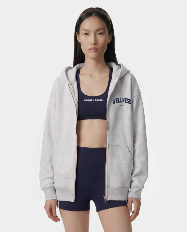 Presenting the Wellness Ivy Zip Hoodie in Heather Gray/Light Navy: an oversized-fit, 100% cotton zip-up hoodie featuring "WELLNESS" in light navy text on the left chest, complete with front pockets and a comfortable hood.