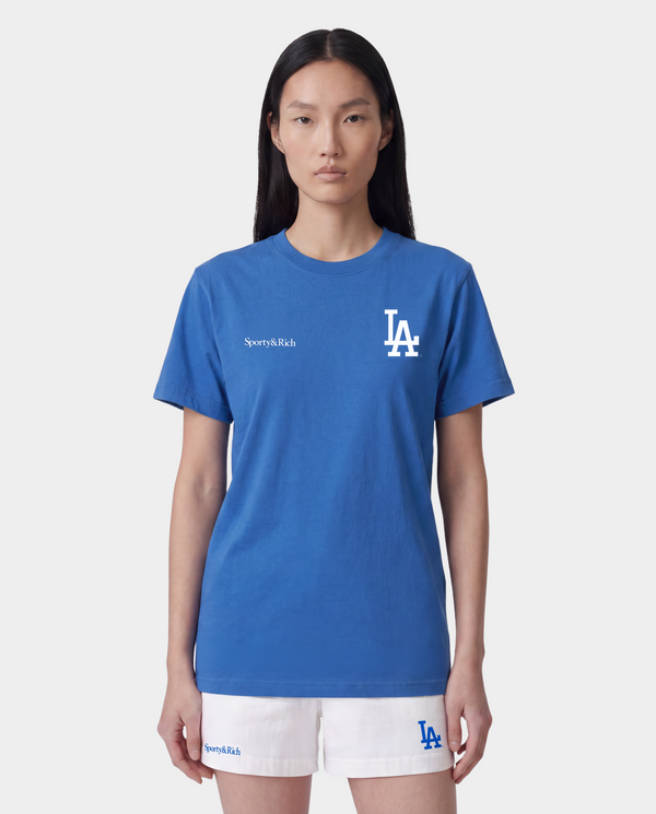 Dodgers Serif T-Shirt in Team Blue/White, featuring an LA logo and Sporty & Rich text on the front, crafted from 100% cotton for comfort, designed with an oversized fit, and shown against a plain background.