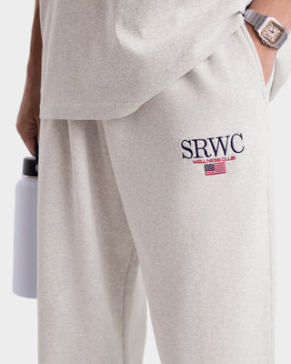 Gray sweatpants with 'SRWC' logo and American flag design, worn by a person.