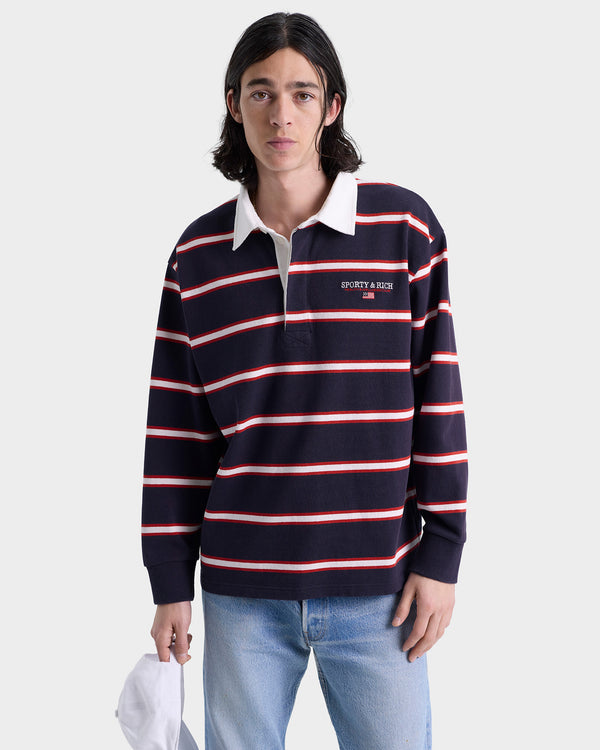 Person wearing a navy and red striped long-sleeve polo with a white collar on a light gray background