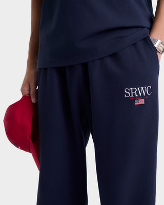 Navy blue pants with 'SRWC' logo held by a person against a white background