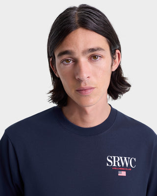 Person wearing a navy blue sweatshirt with 'SRWC' logo on a light gray background