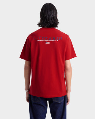 Person wearing a red t-shirt with branding on the back against a white background
