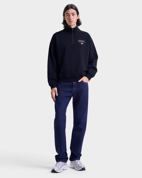 Person wearing a dark navy sweatshirt and pants on a white background