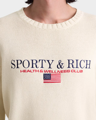 Beige sweater with 'Sporty & Rich Health & Wellness Club' text and American flag logo.