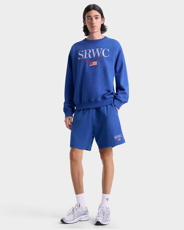 Person wearing a blue 'SRWC' sweatshirt and shorts on a white background