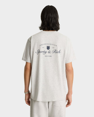 Person in gray Syracuse T-Shirt - Heather Gray/Navy and pants, seen from the back; shirt says Sporty & Rich, Polo and Racquet Club, New York. Crafted with USA grown cotton for comfort.