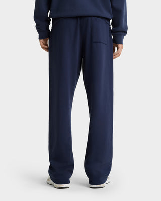 Person wearing the Syracuse Embroidered Crewneck in navy/white, made from USA-grown cotton, viewed from behind and standing on a white surface.