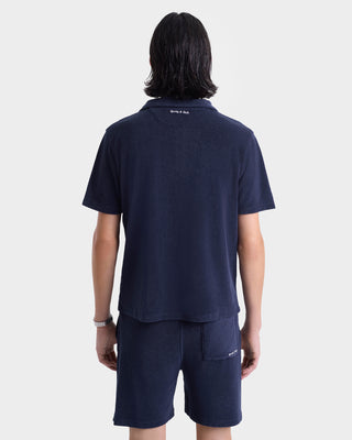 A person shown from the back wears a navy short-sleeve shirt and Eden Script Terry Short - Navy/White, both made from 100% cotton.