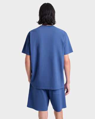 Person wearing a blue t-shirt and shorts set on a white background