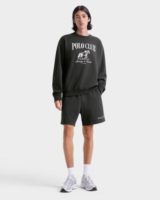 Person wearing a black 'Polo Club' sweatshirt and shorts on a white background