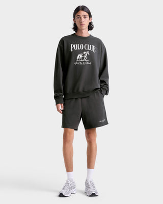 Person wearing a dark gray 'Polo Club' sweatshirt and shorts on a white background