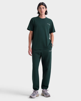 Person wearing a green t-shirt and pants set on a white background