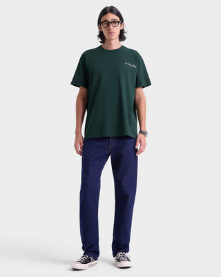 Person wearing a green t-shirt and navy pants on a white background