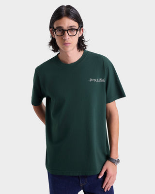 Person wearing a green t-shirt with a logo on a white background