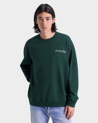 Person wearing a green sweatshirt with a logo on a white background