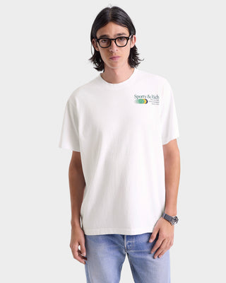 Person wearing a white t-shirt with a logo on a plain background