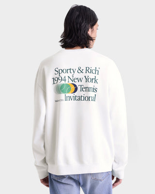 Person wearing a white sweatshirt with text and logo on the back, standing against a plain background