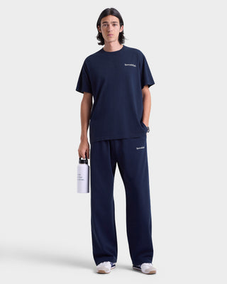 Person wearing navy blue outfit with brand logo on a white background