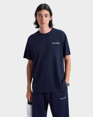 Person wearing a navy t-shirt with a logo on a white background