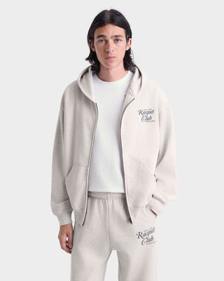 Person wearing a beige tracksuit with 'Ragged Club' branding on a white background