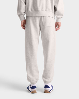 Person wearing a gray tracksuit with white background