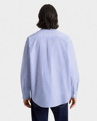 Person wearing a light blue striped shirt on a white background