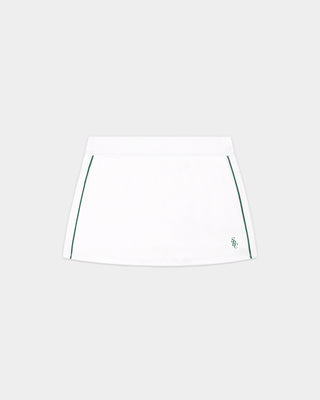 The Alia SRC Court Skirt - White/Forest features green piping along the sides and a small logo on the lower right, complete with built-in shorts for added comfort, displayed against a plain background.