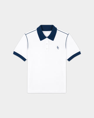 The Flint SRC 70S Pique Polo in White/Dark Navy features a crisp white piqué fabric with dark navy collar, sleeve cuffs, and piping. A small embroidered logo on the chest adds a classic 70s tennis polo vibe.