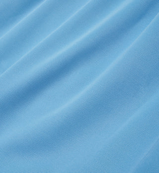Close-up of light blue, comfortable fabric with subtle diagonal texture and soft, flowing folds—ideal for Runner Track Pants - Atlantic/White with an elastic waistband.